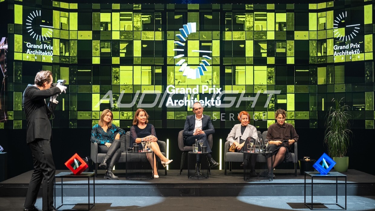 soutěžící na podiu před lomenou LED tsěnou